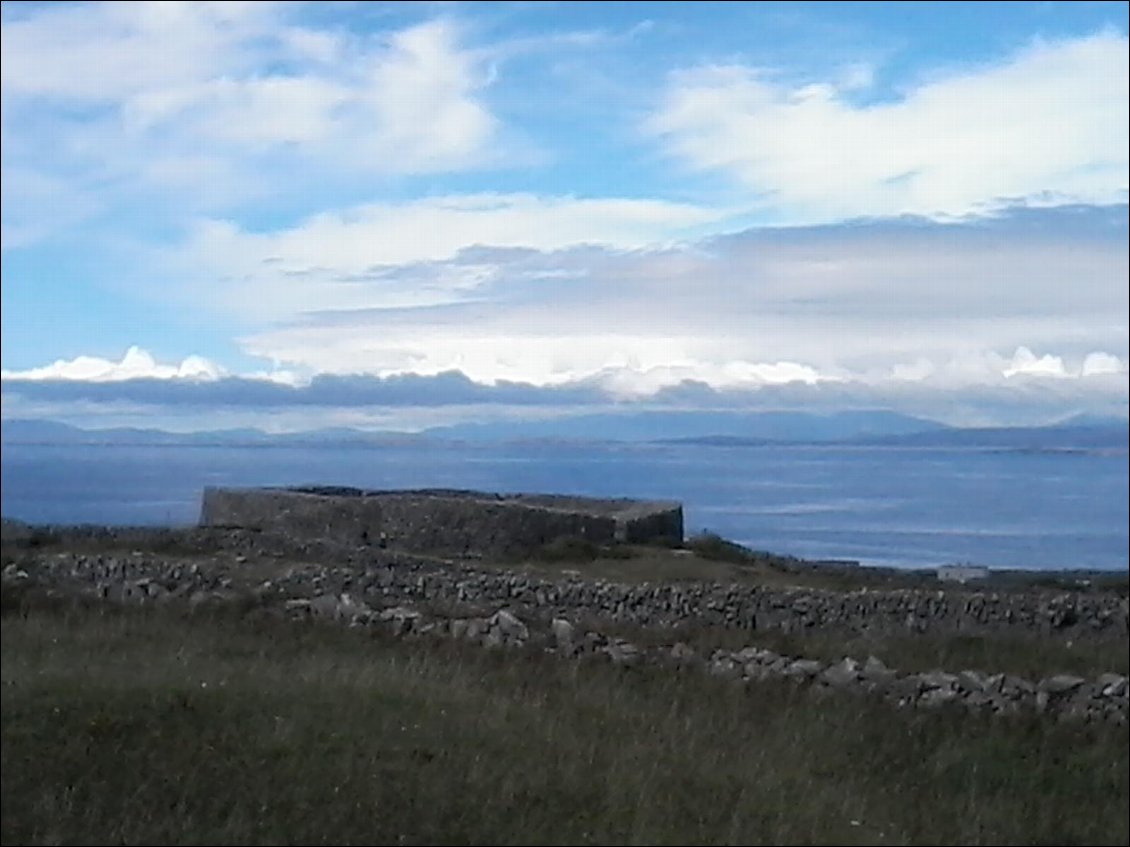 L'île possède plusieurs forts de pierre de l'âge du bronze et du fer. Voici Dùn Eoghanachta. On aperçoit les montagnes du Connemara au fond.